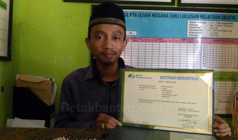 Kepala MTs Daaruttasihah Eva Nurohman menunjukkan sertifikat BPJS Ketenagakerjaan.