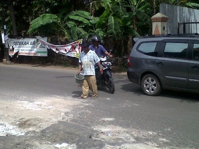 Ide cemerlang Lukman dengan menambal lubang jalanan sambil meraih rezeki