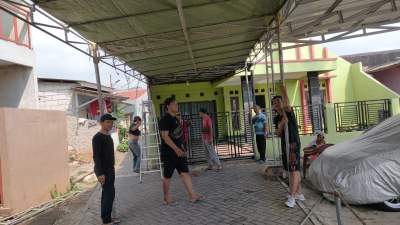 Sejumlah warga di RT 02/05 Kampung Rawa Barat, Pondok Pucung, Kecamatan Pondok Aren gotong royong dirikan tenda untuk pencoblosan surat suara Pemilu 14 Februari 2024 esok. (foto: Muhidin)