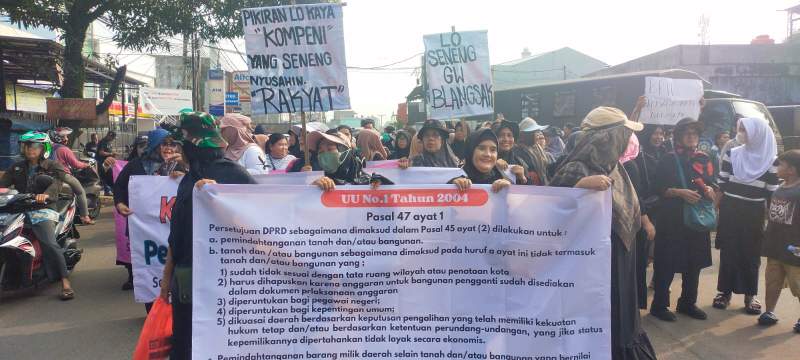 Warga Setu bentangkan spanduk penolakan penutupan jalan oleh BRIN.