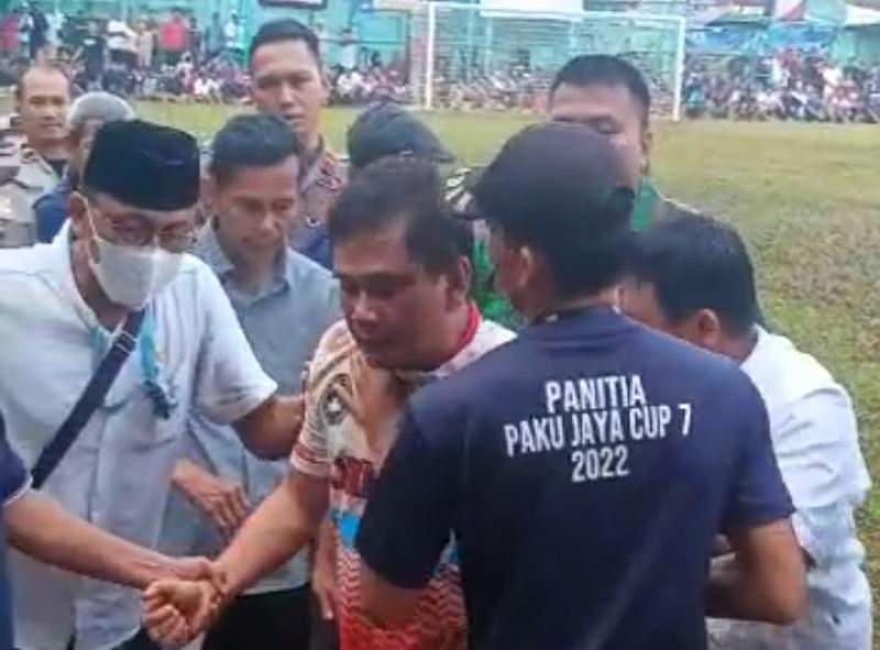 Edi Mamat jersey putih merah (tengah) dibawa panitia keluar lapangan pertandingan.