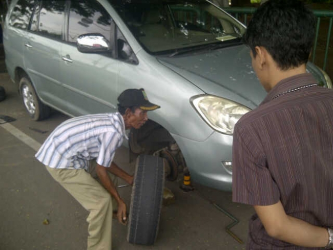 Agus saat mengganti ban yang kempes
