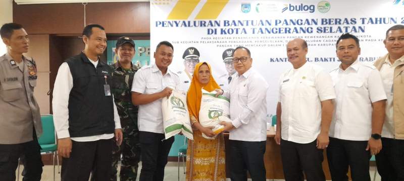Ketua DPRD Kota Tangsel Abdul Rasyid menyerahkan bantuan beras kepada salah satu warga di Kelurahan Bakti Jaya, disaksikan Kadis DKP3, perwakilan Bulog Tangerang dan Muspika Kecamatan Setu.