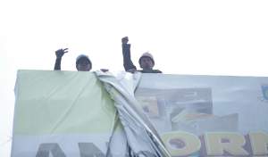 Petugas Pol PP Tangsel saat mencopot APK yang terpasang pada billboard di Jalan Raya Rawa Buntu, Serpong.