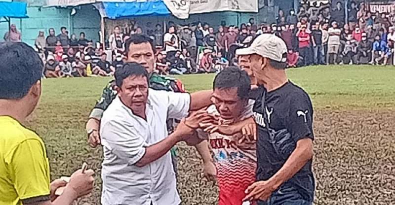 Edi Mamat, jersey putih merah dibawa panitia keluar lapangan pertandingan.