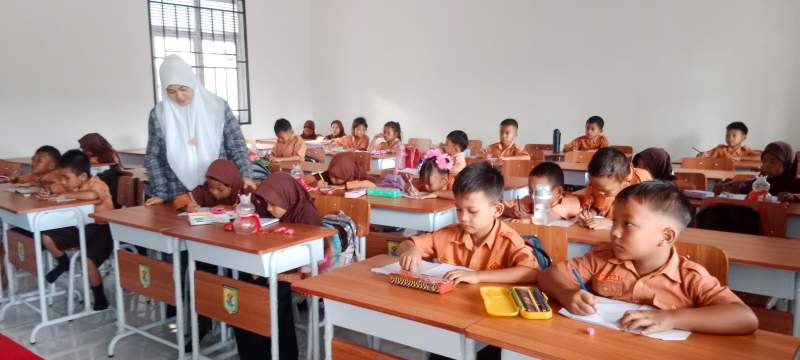 Siswi belajar dengan gedung sekolah yang baru